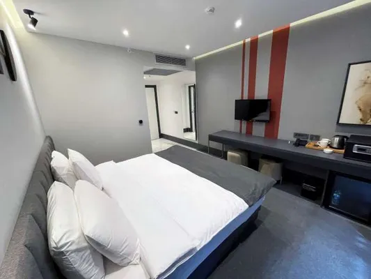 Bed, study desk and minibar in the Standard Room