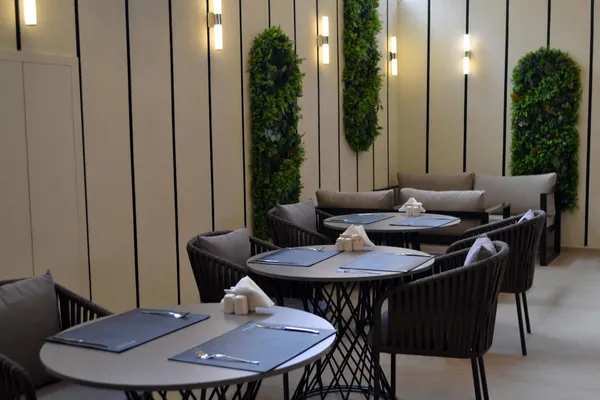 Round tables and a plant wall in the restaurant