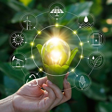 Hand holding a light bulb with sustainability icons